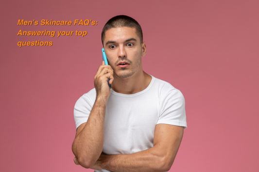 Young man in a white t-shirt talking on a smartphone with a surprised expression, with text overlay reading “Men’s Skincare FAQ’s: Answering your top questions.